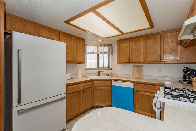6045 S Klamath Loop, Fort Mohave, AZ 86426 - kitchen with white appliances, a sink, light countertops, under cabinet range hood, and a peninsula