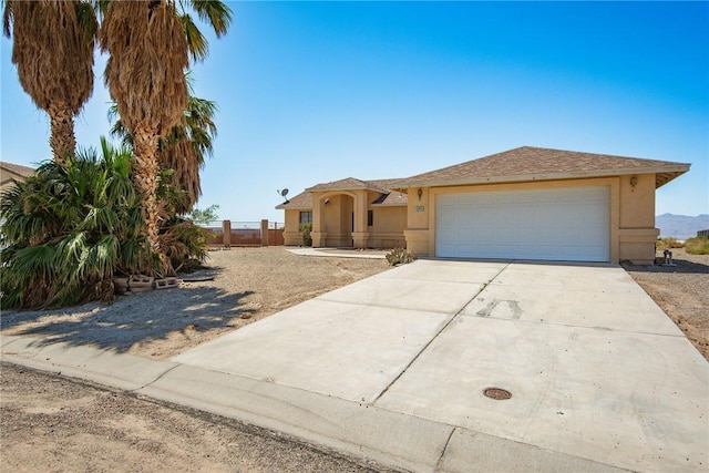 6045 S Klamath Loop, Fort Mohave, AZ 86426 - view of front of house with stucco siding, driveway, an attached garage, and fence