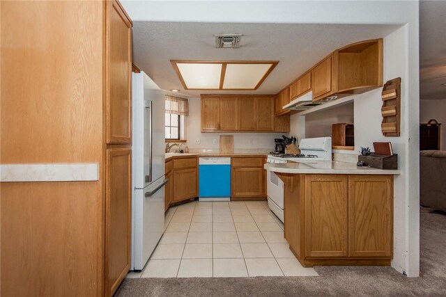 6045 S Klamath Loop, Fort Mohave, AZ 86426 - kitchen featuring white appliances, light countertops, light tile patterned flooring, a peninsula, and brown cabinetry