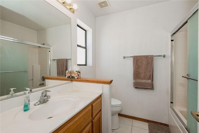 6045 S Klamath Loop, Fort Mohave, AZ 86426 - full bathroom featuring tile patterned flooring, toilet, vanity, baseboards, and bath / shower combo with glass door