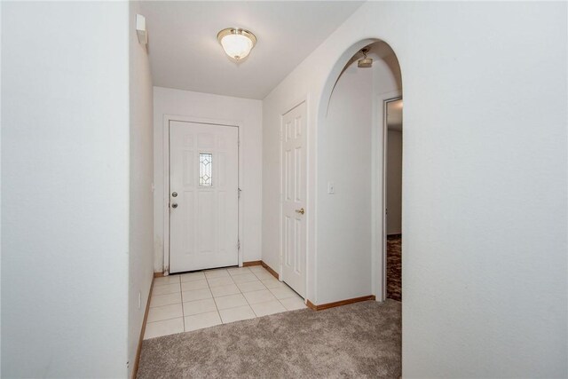 6045 S Klamath Loop, Fort Mohave, AZ 86426 - entryway featuring light carpet, arched walkways, baseboards, and light tile patterned floors