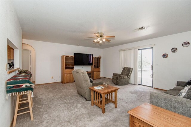 6045 S Klamath Loop, Fort Mohave, AZ 86426 - living area with ceiling fan, light carpet, arched walkways, and baseboards