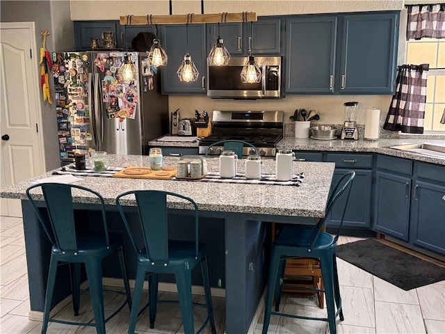 3483 Via Los Pozos, Bullhead City, AZ 86442 - kitchen featuring appliances with stainless steel finishes, blue cabinets, a kitchen breakfast bar, and a kitchen island