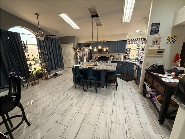 3483 Via Los Pozos, Bullhead City, AZ 86442 - kitchen featuring stainless steel appliances, a kitchen breakfast bar, hanging light fixtures, a kitchen island, and a ceiling fan