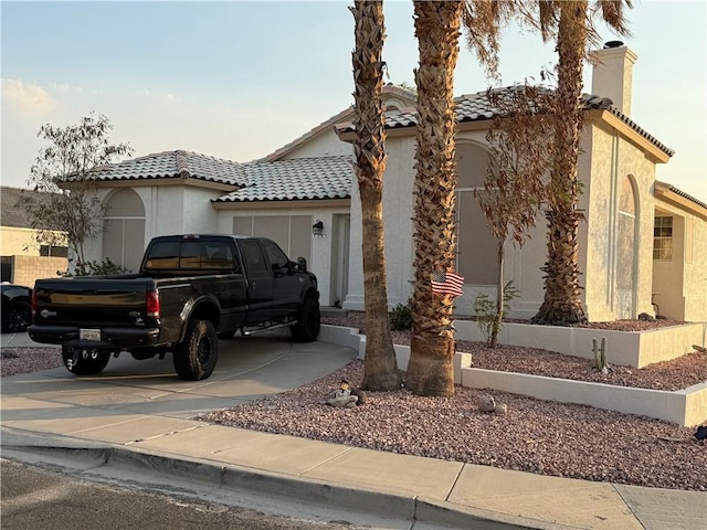 3483 Via Los Pozos, Bullhead City, AZ 86442 - mediterranean / spanish-style home with concrete driveway, a chimney, stucco siding, a tile roof, and an attached garage