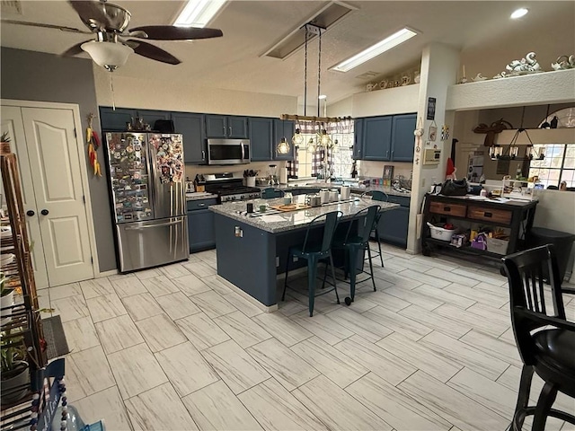 3483 Via Los Pozos, Bullhead City, AZ 86442 - kitchen featuring stainless steel appliances, a breakfast bar, ceiling fan, lofted ceiling, and a kitchen island