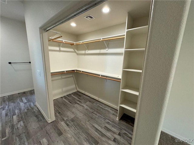 spacious closet with dark wood-style floors and visible vents