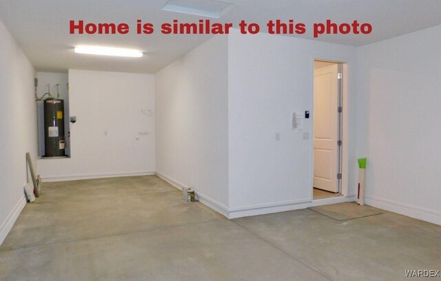 unfurnished room featuring water heater, baseboards, and concrete flooring