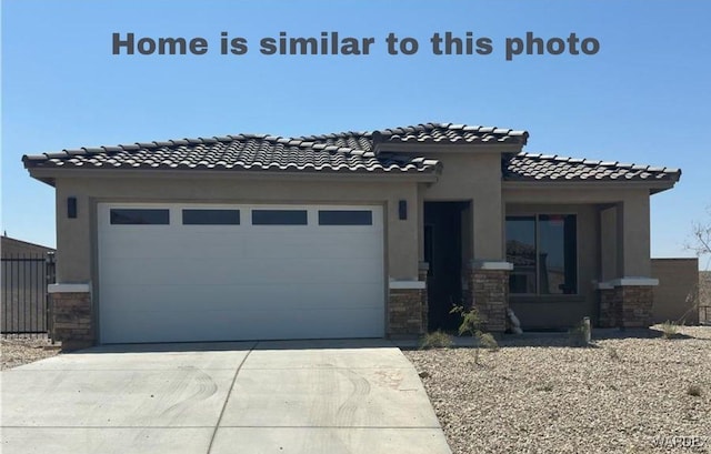 view of front of house featuring an attached garage, stone siding, concrete driveway, and stucco siding