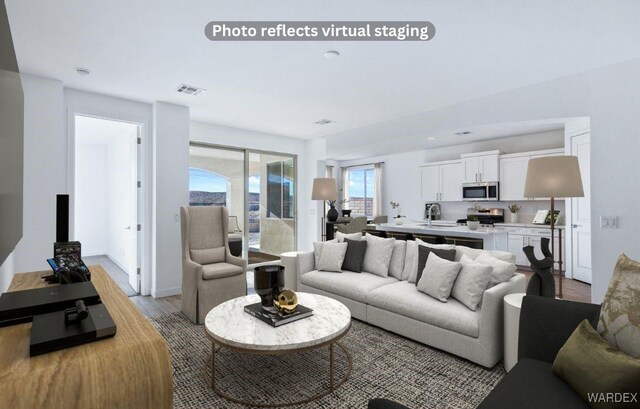 living room with light wood-type flooring, baseboards, and visible vents