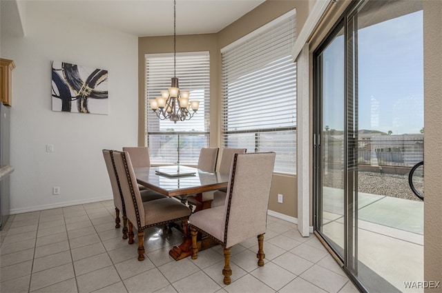 dining area featuring a wealth of natural light, light tile patterned floors, baseboards, and an inviting chandelier