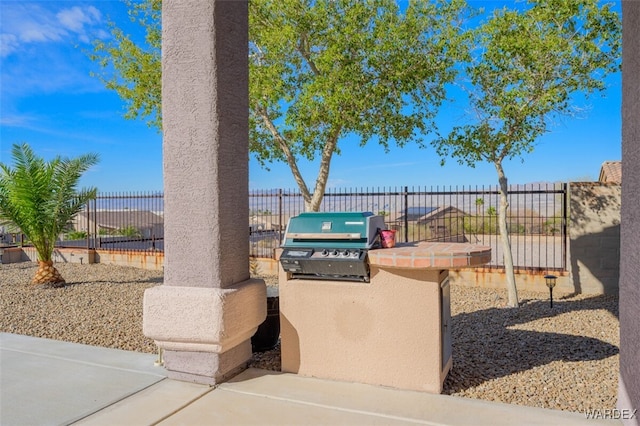 view of patio with fence, grilling area, and exterior kitchen