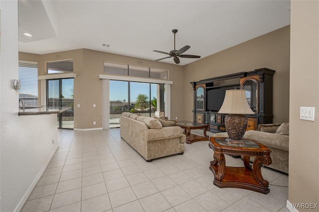 living room featuring a ceiling fan, light tile patterned flooring, and baseboards