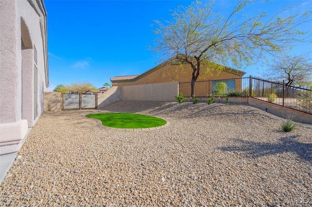 view of yard featuring a gate and a fenced backyard