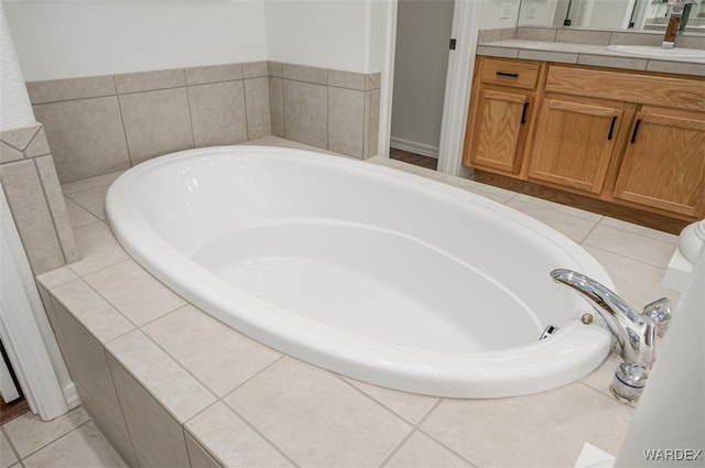 bathroom featuring tile patterned flooring, vanity, and a bath