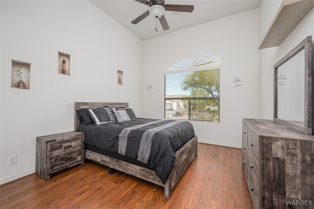 bedroom with lofted ceiling, baseboards, ceiling fan, and hardwood / wood-style floors