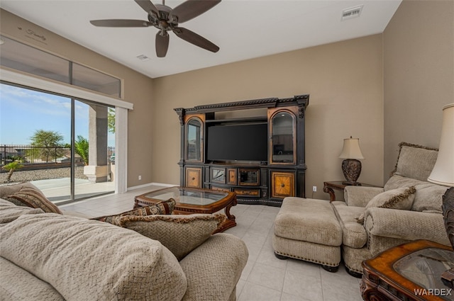 living room featuring light tile patterned floors, ceiling fan, visible vents, and baseboards