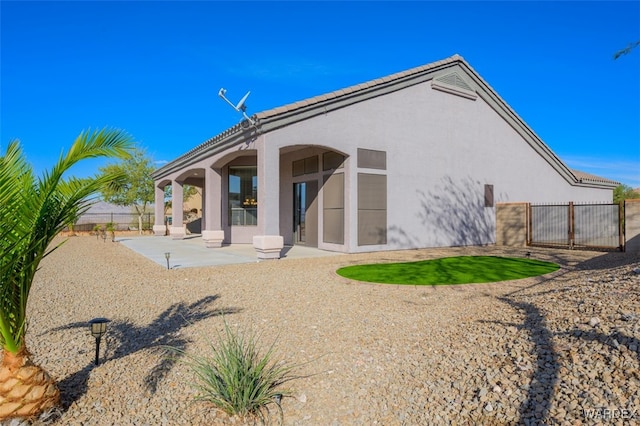 back of house featuring a patio, fence, and stucco siding