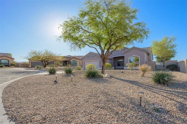 view of front of house featuring an attached garage, fence, and a gate