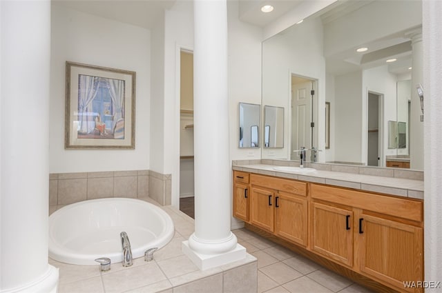 bathroom featuring tile patterned floors, decorative columns, a bath, and vanity