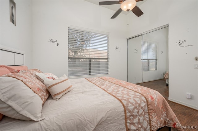 bedroom featuring baseboards, multiple windows, a ceiling fan, and wood finished floors