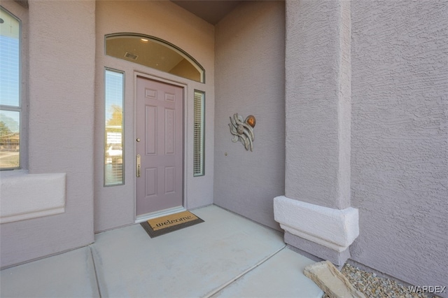 entrance to property with stucco siding