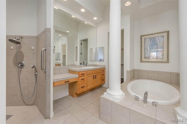 bathroom featuring vanity, tiled shower, a garden tub, and decorative columns