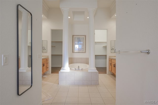 bathroom featuring a garden tub, decorative columns, vanity, and tile patterned floors