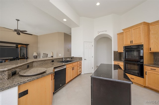 kitchen with arched walkways, decorative backsplash, dark stone countertops, black appliances, and a sink