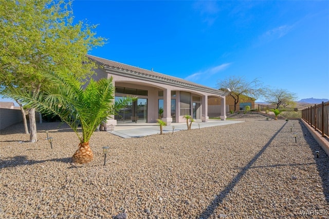 back of property with stucco siding, a fenced backyard, and a patio