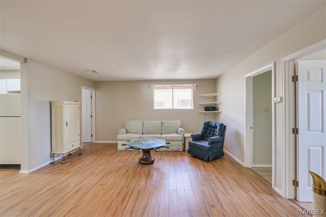 living room featuring baseboards, visible vents, and light wood-style floors