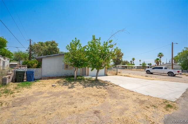 view of yard with driveway and fence