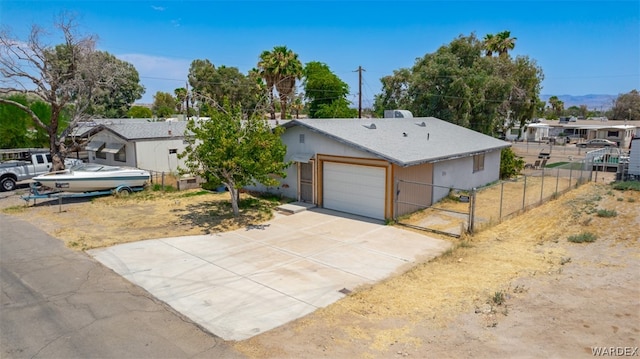 single story home with a garage, concrete driveway, and fence