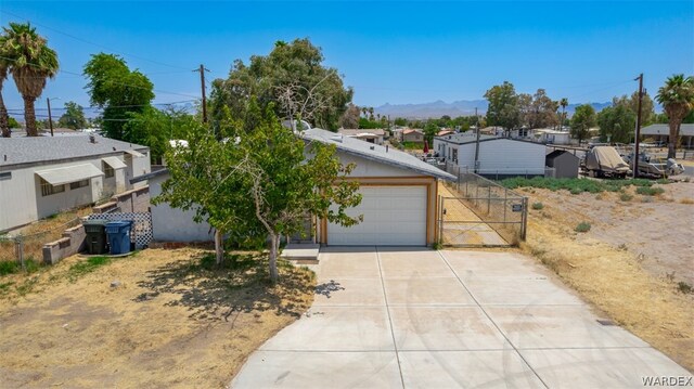 view of front facade with an attached garage, fence, a mountain view, and concrete driveway