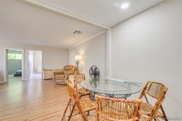 dining room with light wood finished floors, visible vents, and baseboards