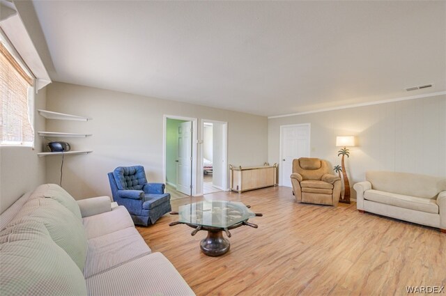 living area featuring light wood finished floors and visible vents