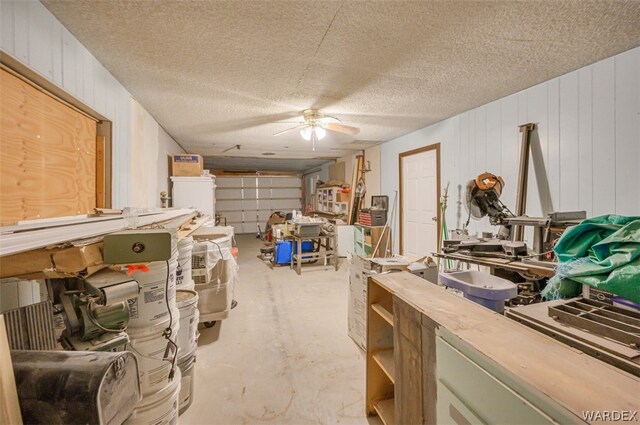 misc room with a textured ceiling, ceiling fan, and unfinished concrete floors