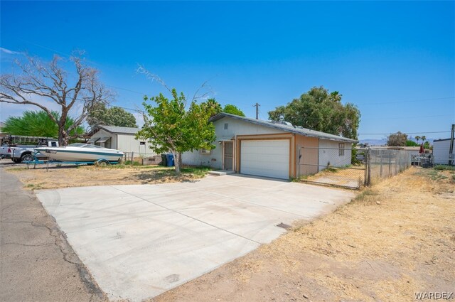 ranch-style home featuring a garage, driveway, and fence