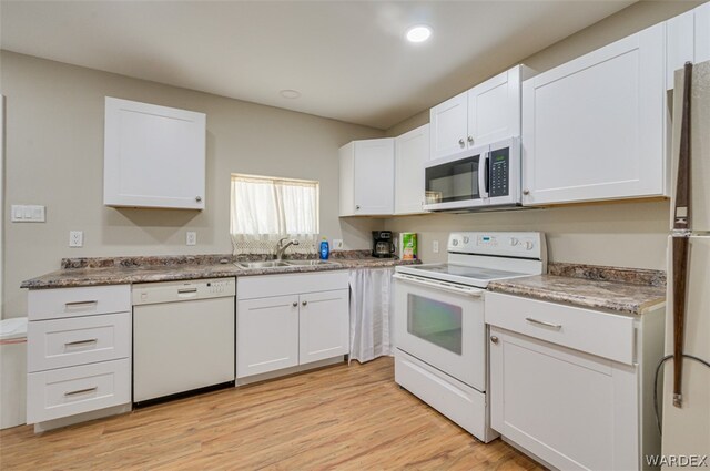 kitchen featuring recessed lighting, white appliances, a sink, white cabinets, and light wood-type flooring