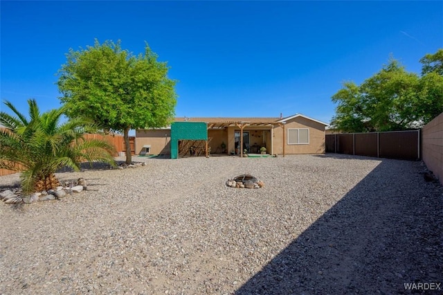 4804 S Baronsgate Way, Fort Mohave, AZ 86426 - rear view of house with a fenced backyard, a fire pit, and stucco siding