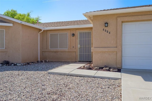 4804 S Baronsgate Way, Fort Mohave, AZ 86426 - view of exterior entry with a garage and stucco siding