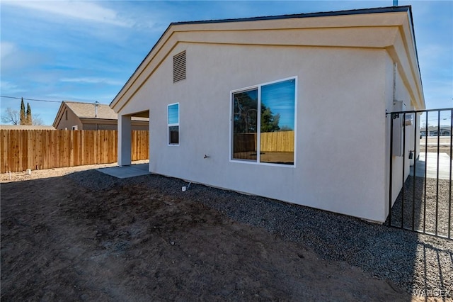 back of house with fence and stucco siding