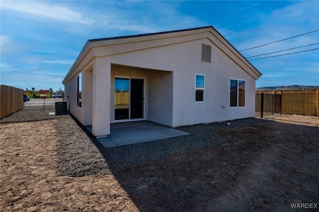 rear view of house featuring central AC, a patio area, a fenced backyard, and stucco siding