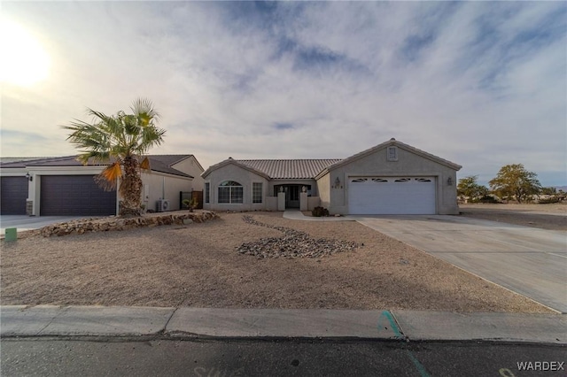 ranch-style home featuring a tile roof, driveway, an attached garage, and stucco siding