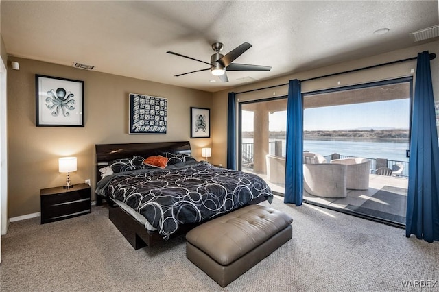 bedroom featuring a water view, access to exterior, visible vents, and carpet floors