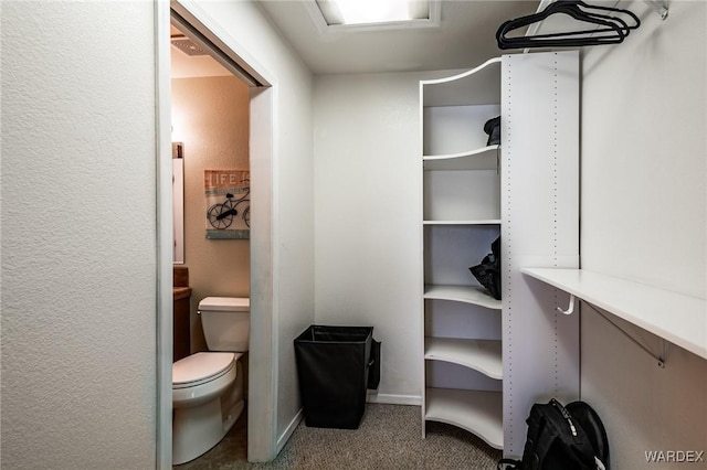 half bath with a textured wall, toilet, and baseboards