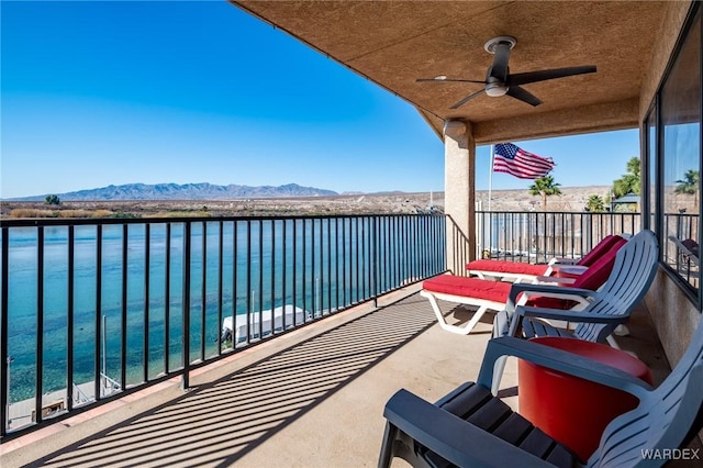 balcony with ceiling fan and a water and mountain view