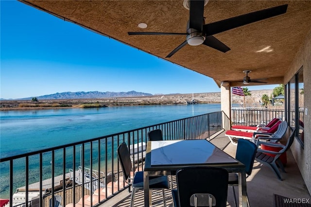 balcony featuring a ceiling fan and a water and mountain view