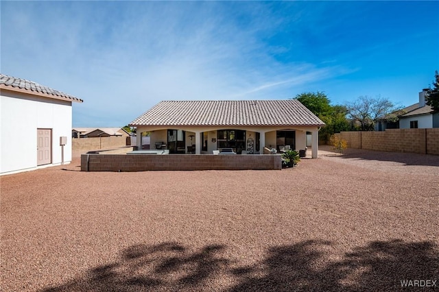 back of house featuring a patio area, a fenced backyard, and a tile roof