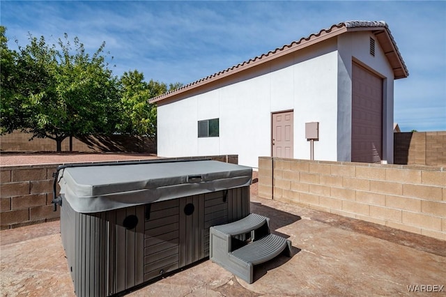 view of patio with fence and a hot tub